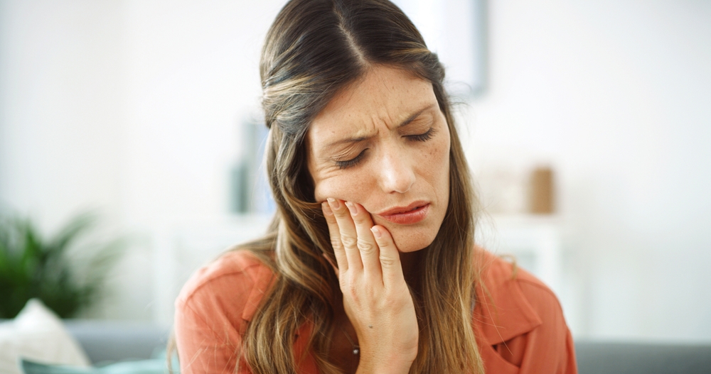 Woman, sore mouth and toothache at house from dental cavity