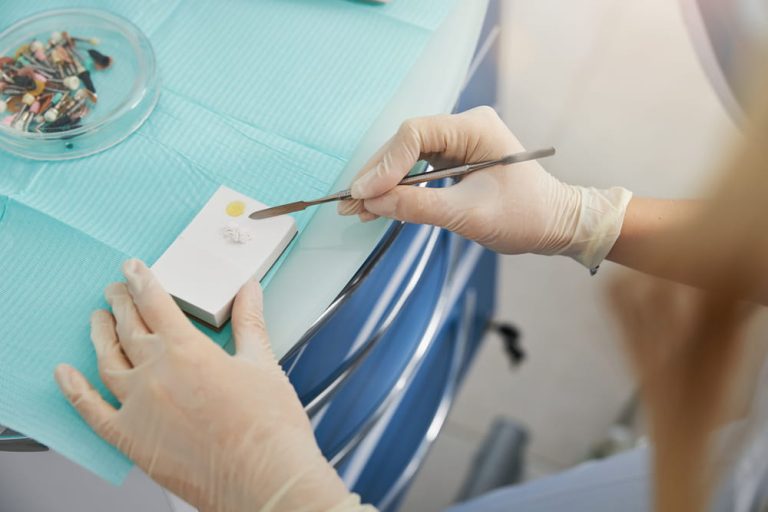 Stomatologist working with dental spatula and cement for fillings