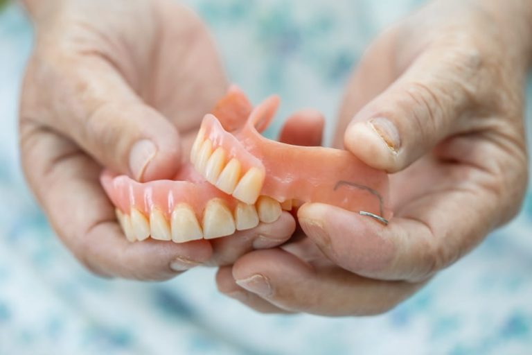 Asian senior or elderly old woman patient holding to use denture in nursing hospital ward,